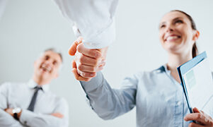 Confident business people shaking hands and woman smiling, recruitment and agreement concept